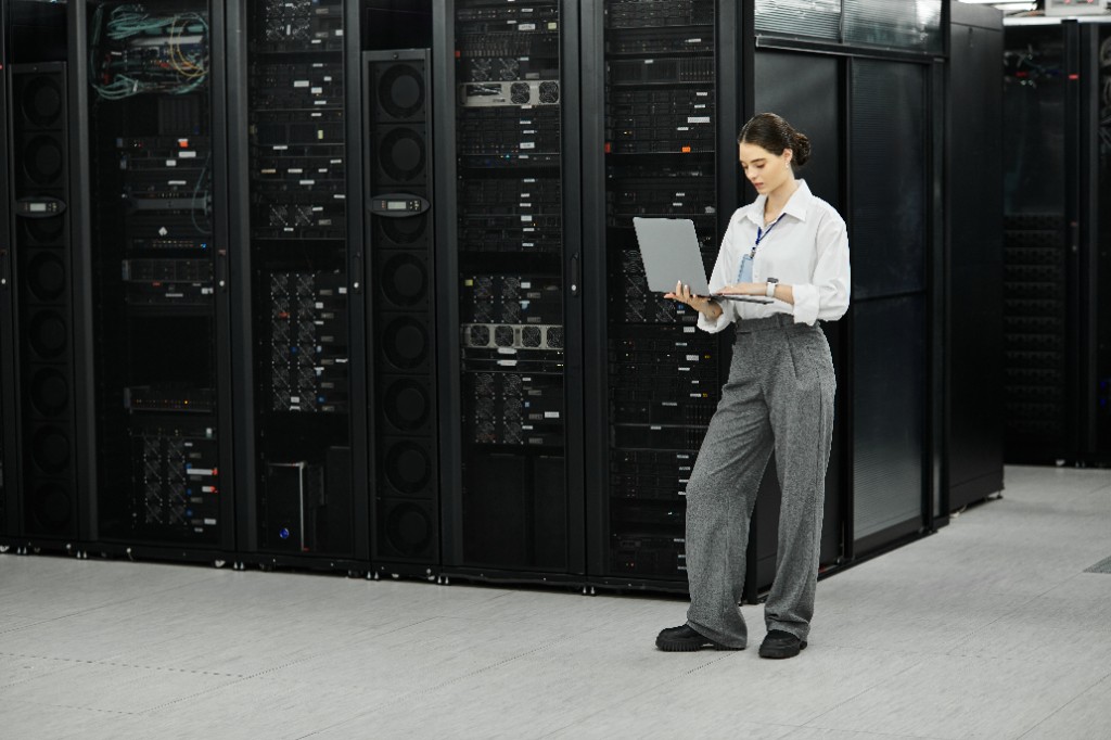 Engineer reviewing systems inside a data center server room.